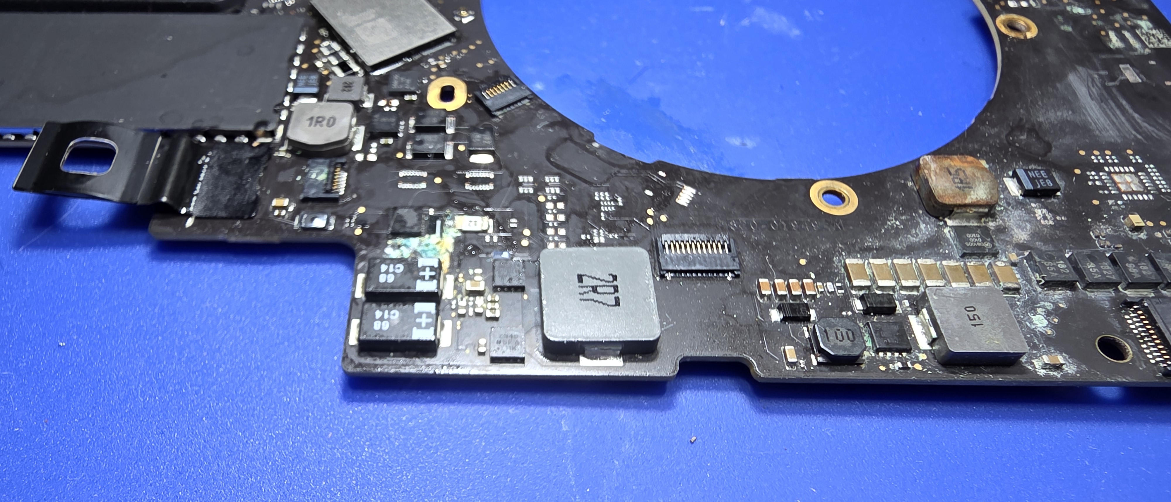 MacBook Pro logic board removed for liquid-damage inspection in Palmdale